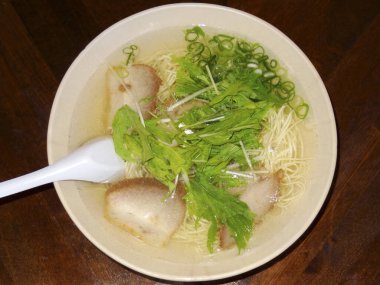 Taze yeşilliklerle süslenmiş şehriye çorbası.