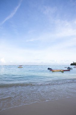 Tropikal tatil beldesindeki kumlu kumsal manzarası.