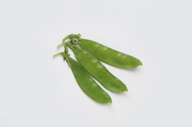 beyaz zemin üzerine taze yeşil bezelye Pod