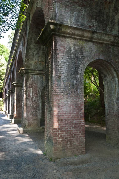 old stone arch bridge in a park