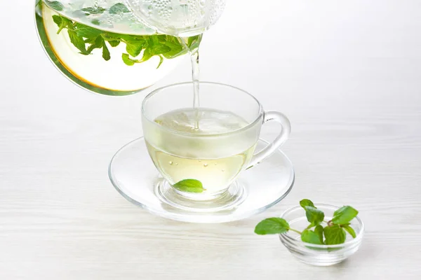 herbal tea with fresh mint leaves on table