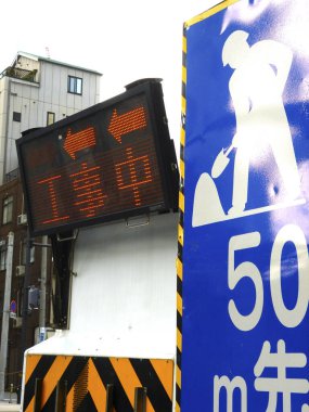 İnşaat uyarı levhasının yanında ok gösteren dijital trafik işareti