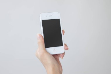 Beyaz arka planda modern akıllı telefonu tutan kadın, yakın plan.