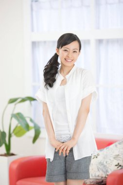 Evde gülümseyen Asyalı kadın.