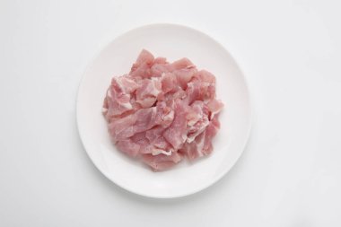 Beyaz arkaplanda tabakta çiğ etin üst görünümü