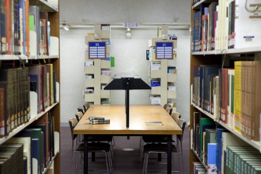 Üniversite kütüphanesinin içi kitaplık ve diğer mobilyalarla dolu