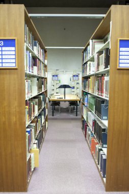 Üniversite kütüphanesinin içi kitaplık ve diğer mobilyalarla dolu