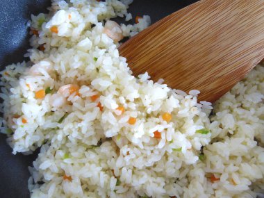 Tavada deniz ürünleri ve sebzeli pilavın yakın plan görüntüsü.