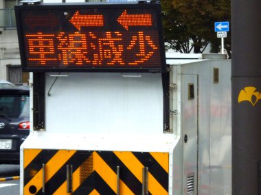 Elektronik yol işareti açık havada Japonca uyarı mesajı gösteriyor.