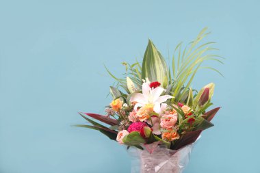 Vazodaki mavi arkaplanda renkli bahar çiçekleri.