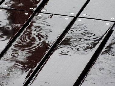 Koyu ahşap arka planda yağmur damlalarının yakın plan görüntüsü