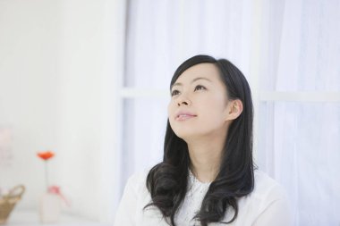 Kadın evine bakıyor.