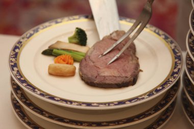 Zarif tabakta biftek dilimliyorum.