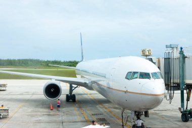 Havaalanına park edilmiş bir uçak ve bulutlu bir gökyüzü