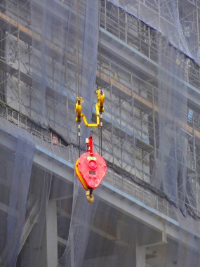 İnşaat alanındaki iskelenin yanında asılı kırmızı makara.