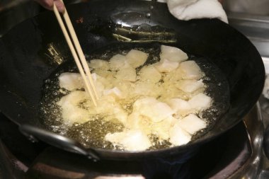 Çubuklarla kızgın yağda balık parçaları kızartıyorum.