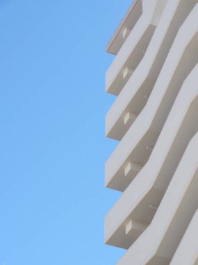 Parlak mavi gökyüzüne karşı modern bir bina.