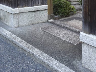 Geleneksel ahşap bina merdivenlerinin yanında taş kaldırım.