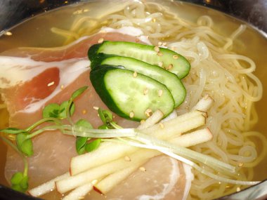 Salatalık ve domuz dilimli makarna kasesi.