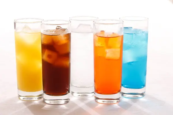 Aydınlık arkaplanda farklı içkiler olan bardaklar.       