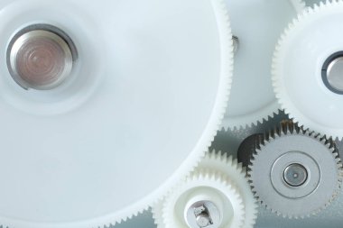 Yakın çekim görüntüsü birkaç beyaz plastik mekanik dişlinin birlikte döndüğünü gösteriyor