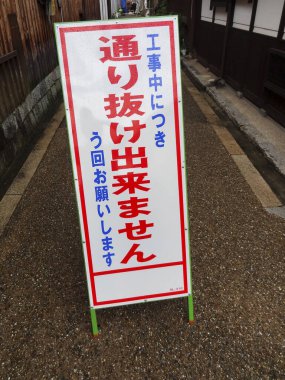 Kırmızı beyaz Japon inşaat tabelası dar sokağı kapatıyor.