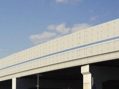 Mavi arkaplan boyunca uzanan beton üstgeçit