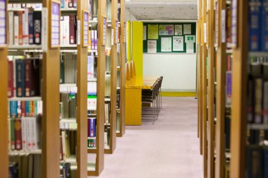 Üniversite kütüphanesi içi kitap rafları ve mobilyalarla dolu