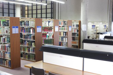 Üniversite kütüphanesi içi kitap rafları ve mobilyalarla dolu