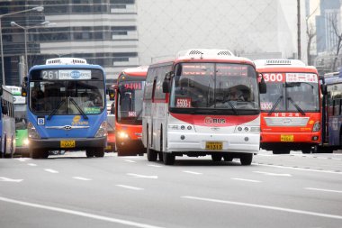 Şehir caddesinde çok sayıda otobüs sürüyor.