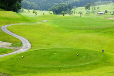Pürüzsüz yeşil çimlerle çevrili huzurlu bir golf sahası.