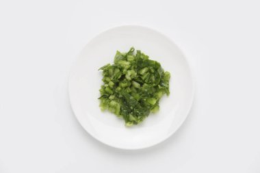 Beyaz tabakta doğranmış yeşil sebzeler