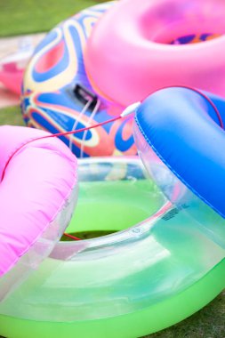 Açık havada renkli şişme havuz halkaları var.