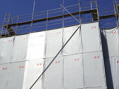 Mavi gökyüzüne karşı inşa edilmiş bir sanayi binası. 