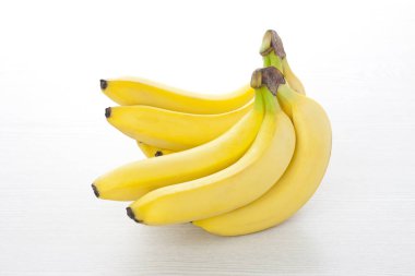 Beyaz ahşap zemin üzerinde taze muz.