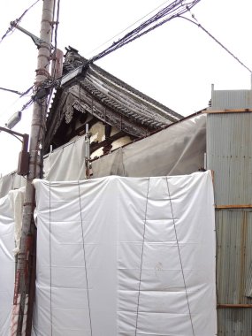 Beyaz muşambaların ve metal tabakaların arkasında yenilenmekte olan eski bina