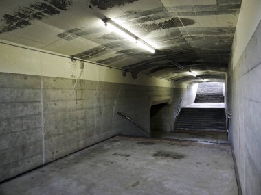 Beton duvarları ve merdivenleri olan boş yeraltı tüneli.