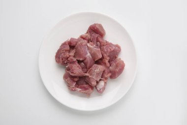 Beyaz zemin üzerinde dilimlenmiş etin üst görünümü.