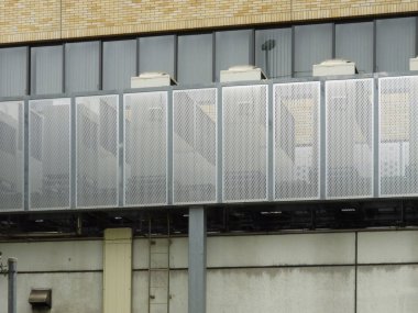 Endüstriyel bina dış duvarını kaplayan yansıtıcı cam paneller