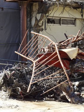 Döküntü ve enkazın arasına atılmış metal sandalye.