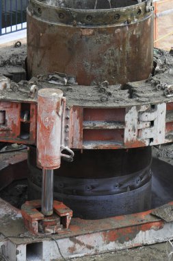 Yakın plan, toprak ve pasla kaplı endüstriyel makineleri gösteriyor.