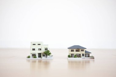 Beyaz arka plandaki küçük ev modelleri, ipotek kavramı