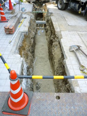 Toprak, su ve inşaat araçlarını gösteren kazılmış siper