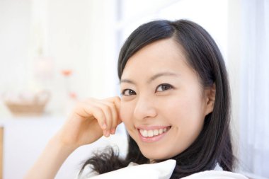 Zarif Japon kadın zarif bir şekilde minimalist beyaz bir odada poz veriyor..