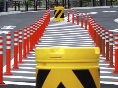 Sarı trafik varilleri kıvrımlı yol yapım bölgesini gösteriyor.