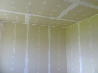 Tamamlanmamış alçıpan odası bantlı dikişleri ve eklem bileşimini gösteriyor