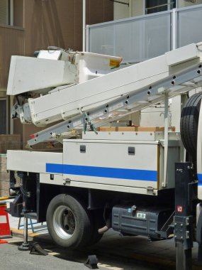 Konut binasının yakınına park edilmiş beyaz servis kamyonu.