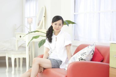 Asyalı kadın kanepede oturan