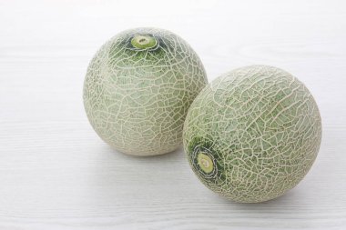 Açık ahşap arka planda taze olgun organik kavunların yakın plan görüntüsü.         