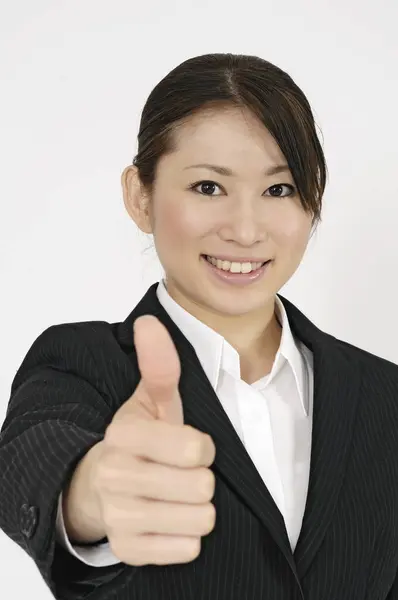 stock image portrait of smiling asian businesswoman showing trumps up on white background 